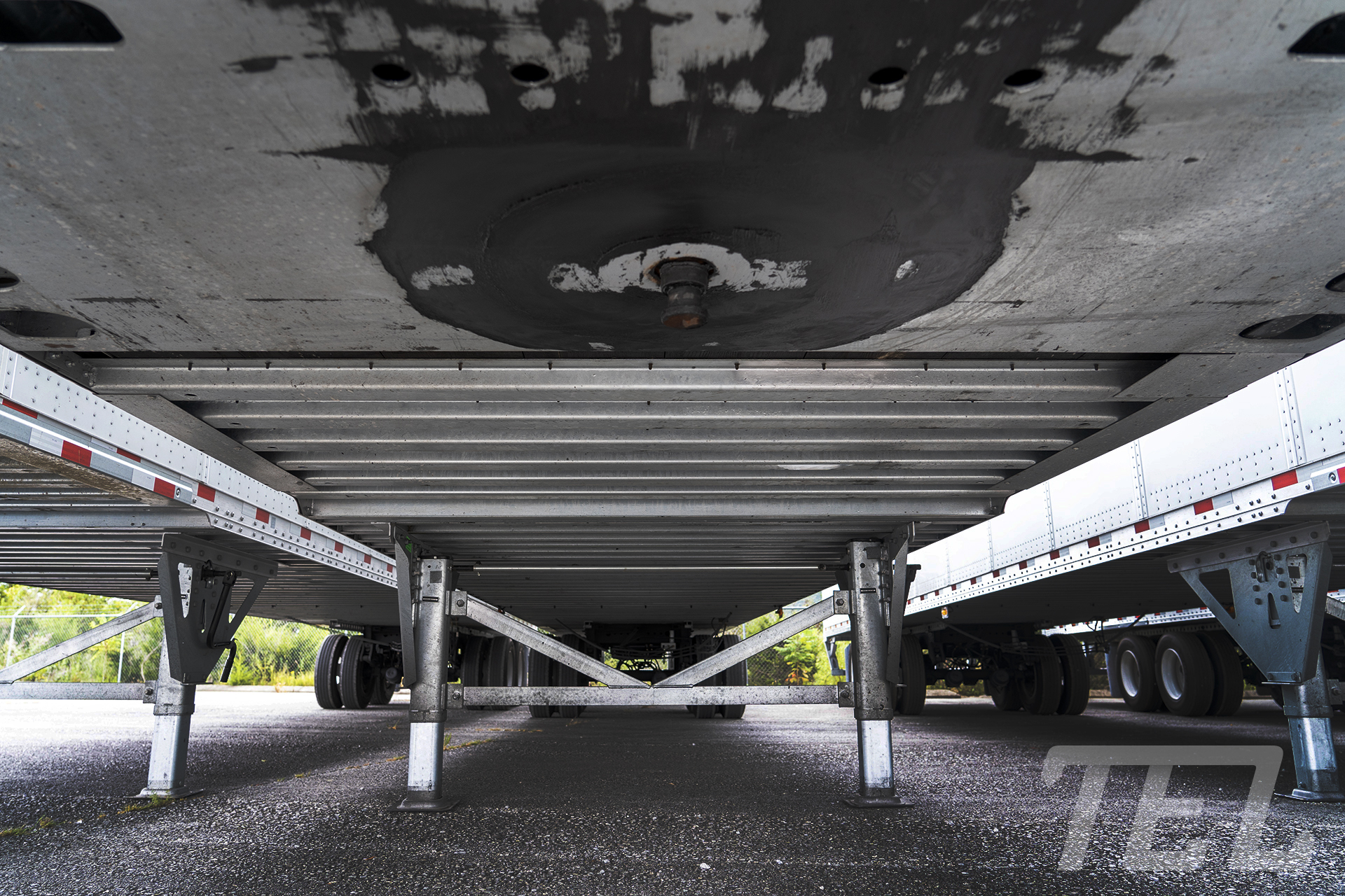 The underside of a TEL Dryvan trailer showing the landing legs and kingpin and level ground